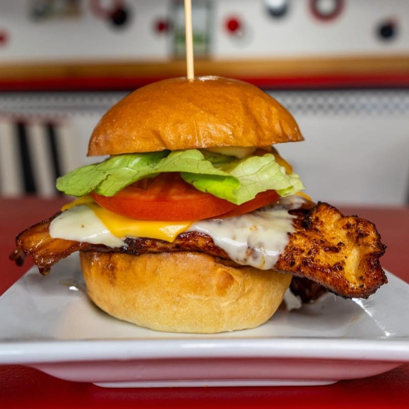 Bergstrom's grilled chicken sandwich with melted cheese, lettuce, and tomato on a bun.